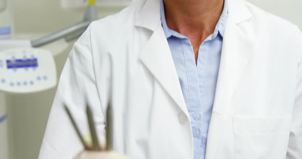 Female dentist holding dental tools