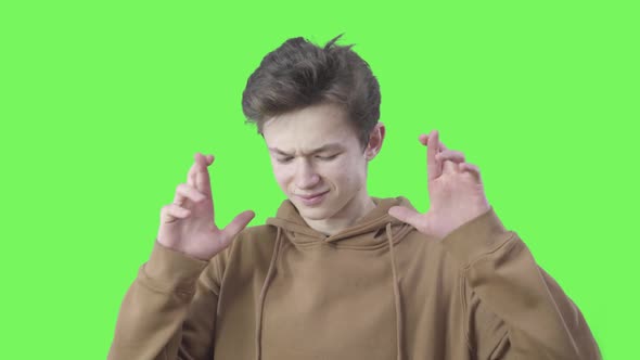 Boy Showing Hope Gesture at Chromakey Background. Portrait of Brunette Young Caucasian Boy Crossing