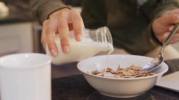 Woman in kitchen pouring milk in corn flakes 4K 4k