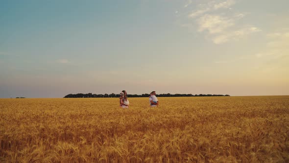 Mom and Dad Carrying Children in Arms in Field