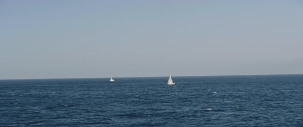 Ocean horizon view with two sail boat during a boat trip