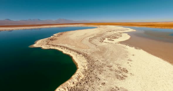 Aerial View of the Multicolored Lake Within the Endless Expanse of Desert