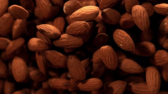 Super Slow Motion Shot of Almonds Flies After Being Exploded Against Black Background, 1000Fps.