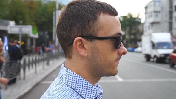 Profile of Young Businessman in Sunglasses Crossing the Road in Downtown. Confident Male