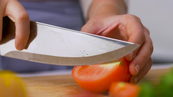 Woman Chopping Tomato with Kitchen Knife at Home