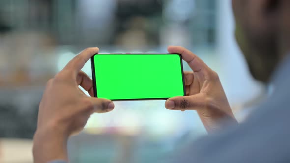 Man Using Smartphone with Green Chroma Key Screen Rear View