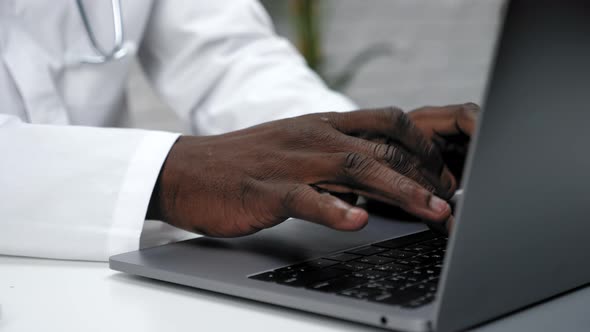 Close Up African American Hands Typing Text on the Keyboard Laptop in Clinic