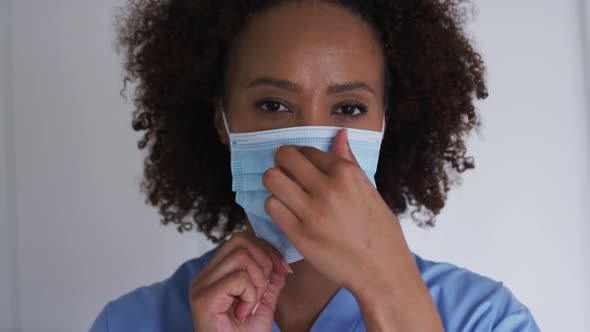 Portrait of mixed race female doctor wearing mask and looking at camera