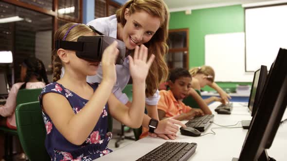Schoolgirl using virtual reality glasses in classroom