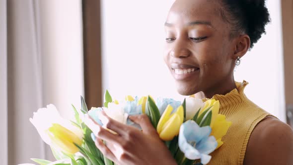 African American Woman Smiling and Looking at Tulips Bunch