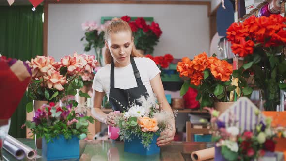 Cheerful Female Florist Decorates a Bouquet of Flowers in a Box Young Woman Working in a Flower and