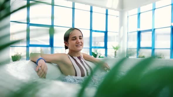 Young Attractive Woman Relaxing in Jacuzzi During Cosmetic Therapy and Body Care