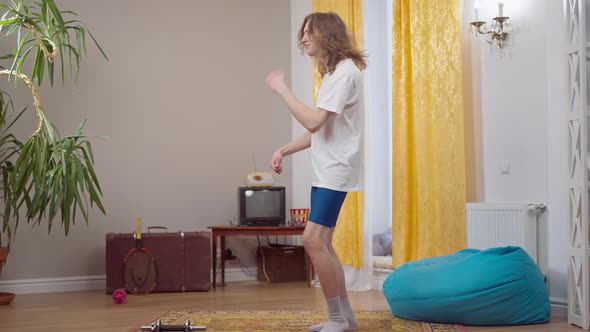 Positive Skinny Young Man Having Fun Training at Home in 1980s 1990s