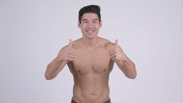 Happy Young Handsome Muscular Shirtless Man Giving Thumbs Up and Looking Excited