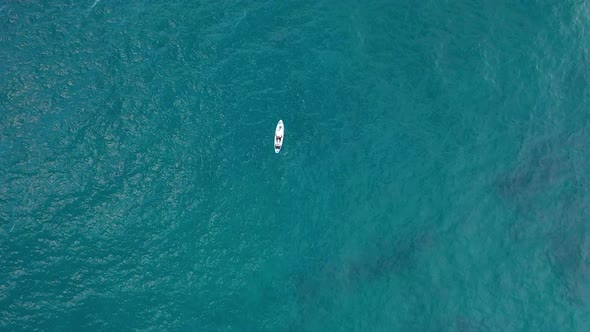 A Girl Swims on a Board in the Open Sea Filmed on a Drone