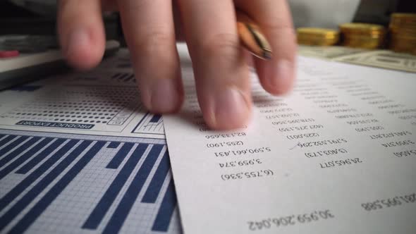 Accountant Analyzing Business Marketing Data on Paper Dashboard at Office Table