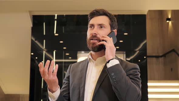 Portrait Handsome Man Having Phone Call in Business Center