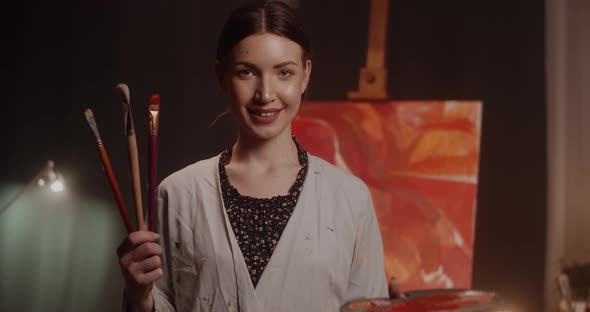Portrait of Young Female Artist with Brushes