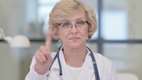 Portrait of Old Female Doctor Showing No Sign with Finger