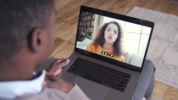 African American Man Video Calling Friend on Laptop at Home