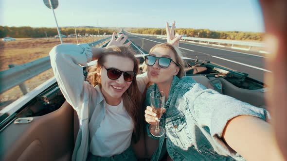 Young Women in Back Seat of Convertible Car and Take Selfies and Fool Around During Ride