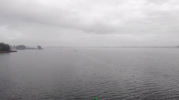 Flying over calm waters on a hazy morning, overcast and hazy weather, a sailboat out on the water