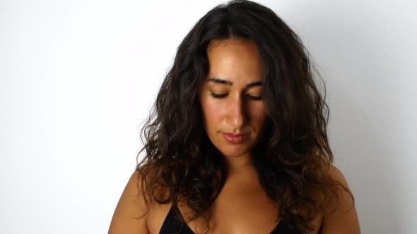 A beautiful mixed-race woman with dark hair smiling and dancing with oranges.