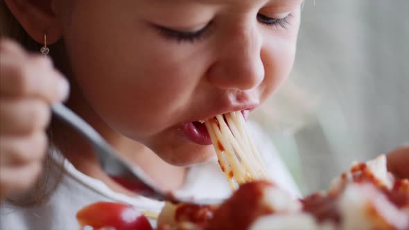 A Child Girl Is Eating Spaghetti Close-up