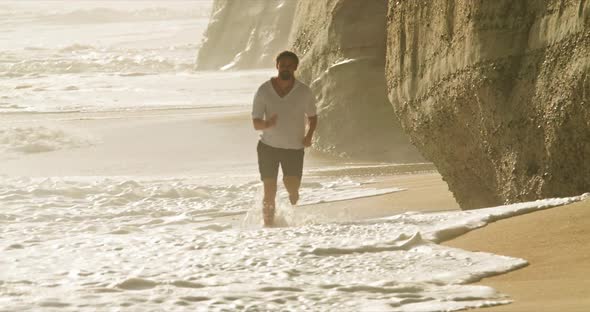 Happy Man Running on Sandy Beach of Nazare Portugal Europe
