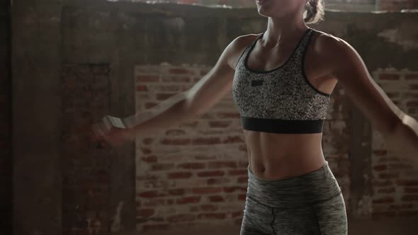 Fit woman doing jumping jack exercise at fitness gym