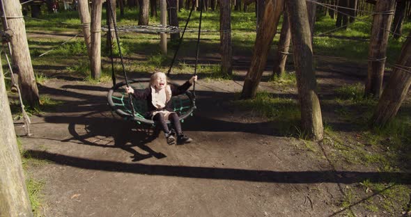 Little Girl Swinging On A Swing In The Recreation Park