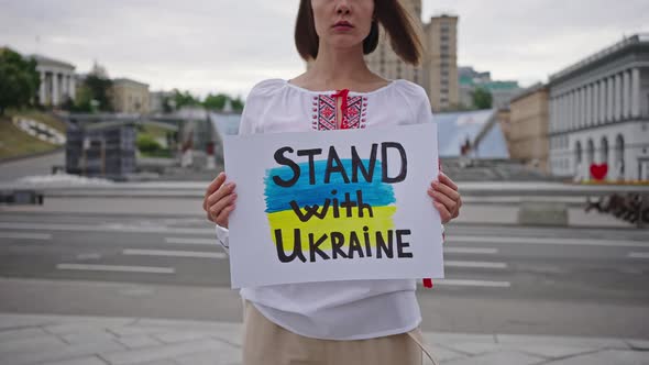 Ukrainian Woman Holds Patriotic Poster Calling for Support