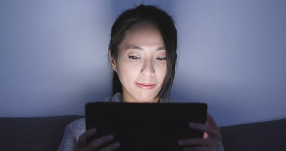 Woman use of tablet computer at night