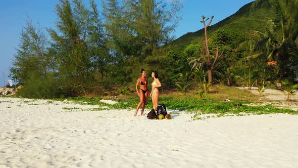 Young beauty models relaxing by the sea on the beach on clean white sand and blue background 4K