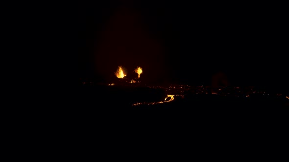 Aerial flying back from an active erupting volcano at night.