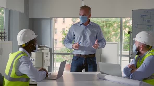 Engineers Team in Safety Mask Meeting for Architectural Project