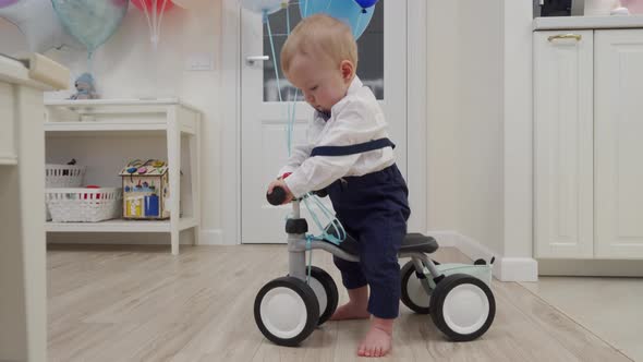 Kid on Baby Bicycle Balance Bike for Toddlers with Colorful Balloons 1 Year Old Baby Boy Celebrating