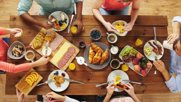 Group of People Eating at Table with Food