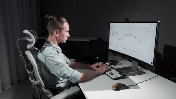 Young Male IT Programmer Smiling To the Camera While Working on His Project