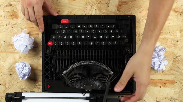Writer Typing Text on a Typewriter Throws Out a Sheet. View From Above