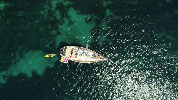 Aerial view above sailboat swinging on agitated waters in the coast of Greece.