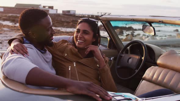 African american couple embracing each other while sitting in the convertible car on the road