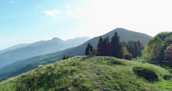 Biker Taking a Picture with Smartphone Aerial Riding Mountain Bike Along Forest Trail in Summer