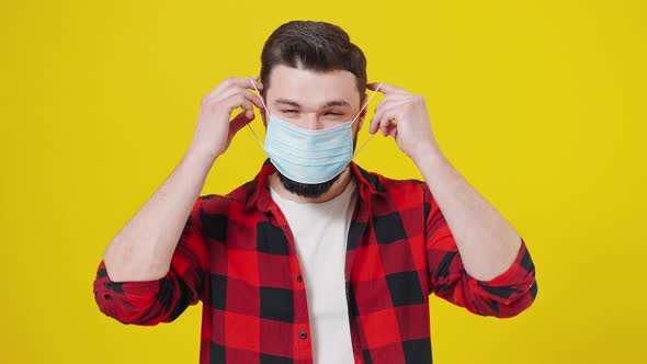 Closeup Portrait of a Young Man Wearing Protective Face Mask Isolated at the Yellow Background with