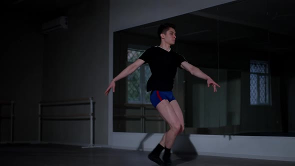 Concentrated Caucasian Young Man Performing Ballet Leaps Rehearsing in Studio Indoors