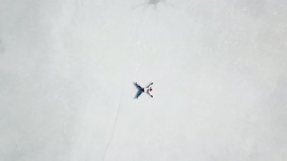 Aerial footage girl layed down on ice