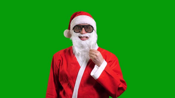 Santa Claus Wearing Black Paper Sunglasses on Stick Over Green Chroma Key Background