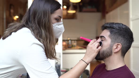 Make-up artist wearing protective mask, applying make-up for wedding