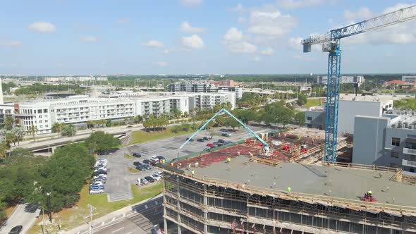 Crew of concrete workers pouring cement on a downtown building