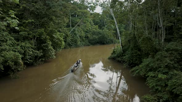 People Exploring In The Amazon Jungle Sailing In Rainforest River. Aerial Shot